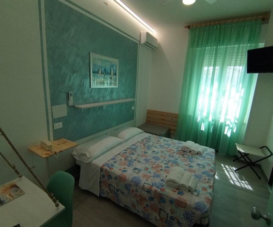 Camera moderna con letto matrimoniale e decorazioni marine.