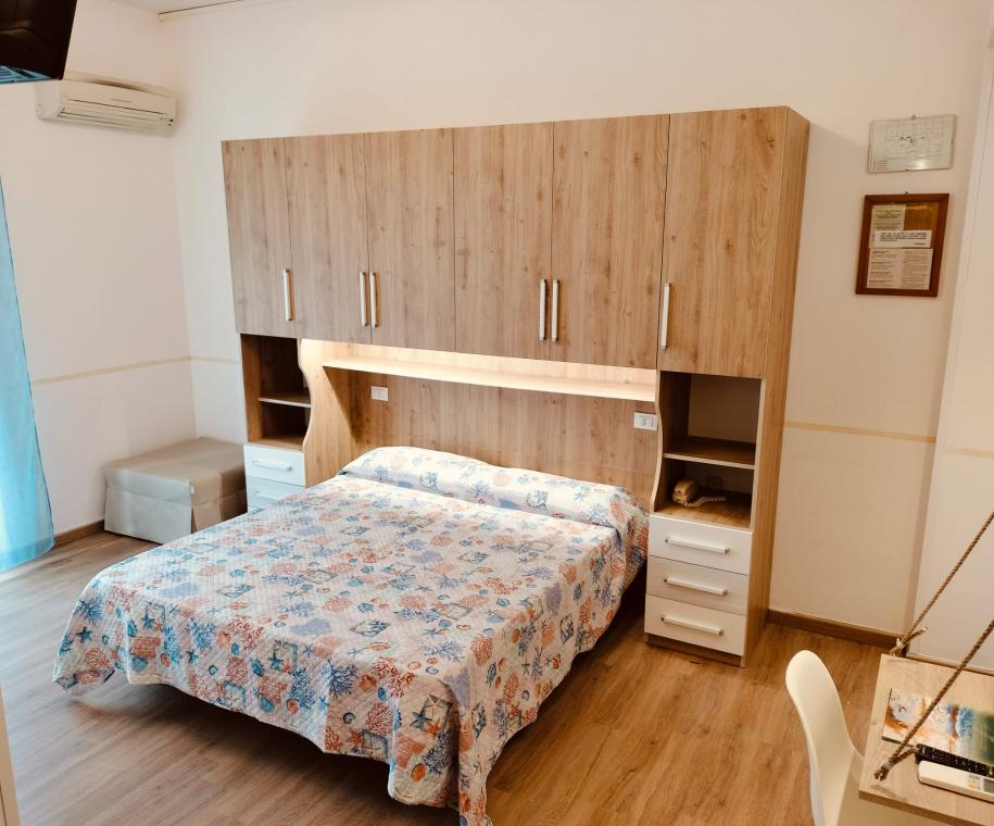 Camera da letto con armadio e letto matrimoniale, arredamento moderno.